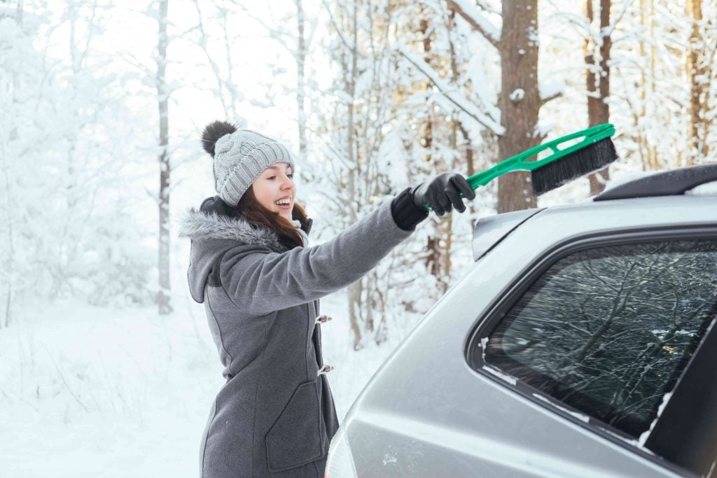 Personne entrain de déneiger sa voiture. 